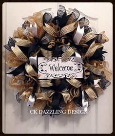 a welcome sign hanging on the front door of a house with black and gold ribbons