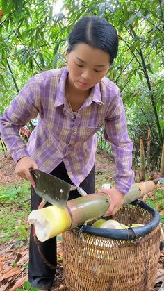 a woman is cutting vegetables in a basket