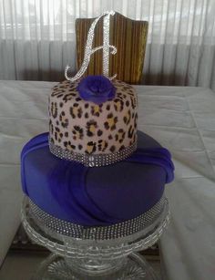 a three tiered cake with blue frosting and leopard print