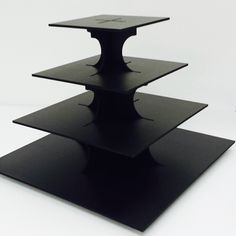 three tiered black cake stand on white background