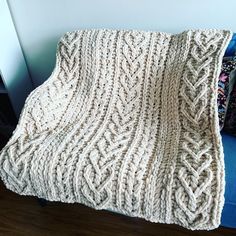 there is a blanket that has been knitted on the couch