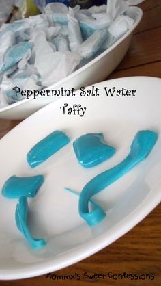 two white bowls filled with blue jello and marshmallows on top of a wooden table