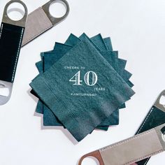 four napkins with the number 40 printed on them next to two pairs of scissors