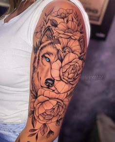 a woman with a wolf and roses tattoo on her arm