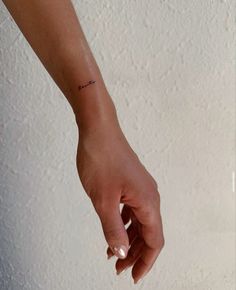 a woman's hand with a small tattoo on it