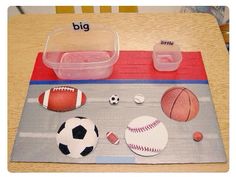 a table topped with plastic containers filled with different types of balls and sports equipment on top of a rug