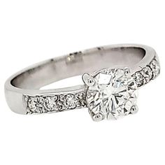 a white gold ring with diamonds on the sides and a center stone in the middle