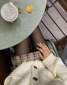 a woman sitting at a table with her legs crossed