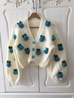 a white sweater with blue roses on it