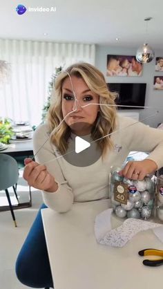 a woman sitting at a table with christmas ornaments in front of her and the caption reads