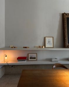 a table with some books on top of it and a framed picture above the shelf