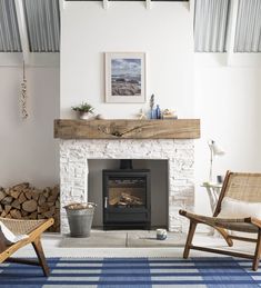 a living room with a fire place and two chairs in front of the fireplace,