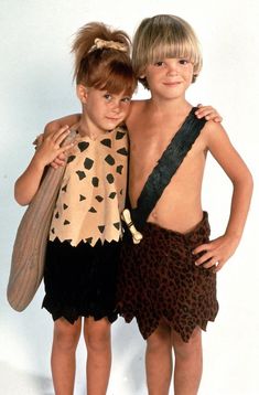 two young children standing next to each other in front of a white background with the caption's name on it