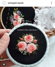 someone is showing off their embroidery work on the back of an embroidered hoop bag with flowers