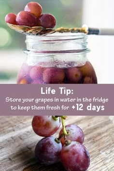 a jar filled with grapes sitting on top of a wooden table