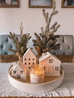 a candle and some houses on a tray