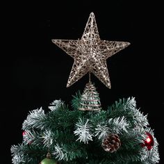 an ornament hanging from the top of a christmas tree with ornaments around it