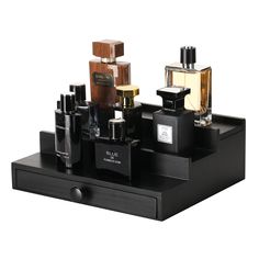 an assortment of perfumes are displayed on a black tray