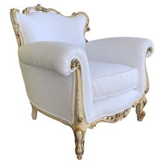 a white chair with gold trimmings on the arms and back, sitting against a white background