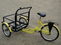 a yellow bike with a basket attached to it's front wheel, parked on the ground