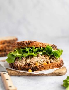 a close up of a sandwich on a cutting board with lettuce and meat