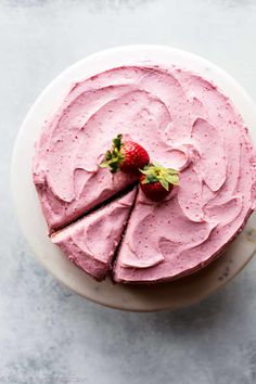 a strawberry cake on a plate with one slice cut out