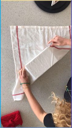 a woman is working on a piece of cloth