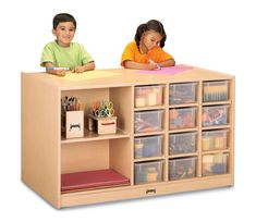 two children sitting at a desk with lots of storage containers