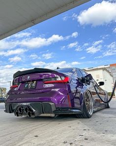 a purple car is parked at a gas station