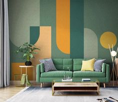 a living room with green couches and colorful wallpaper