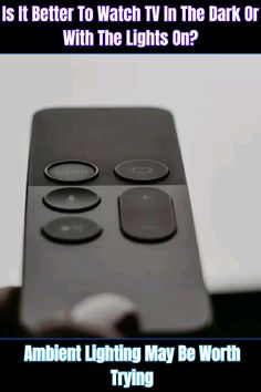 a close up of a remote control with the text, is it better to watch tv in the dark or light?