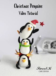 three penguin figurines sitting on top of each other in front of a camera