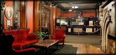 an ornately decorated lobby with red velvet chairs and wooden paneled walls in the background