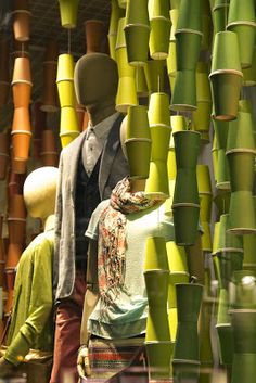 mannequins are standing in front of a display of green and yellow bamboo stalks