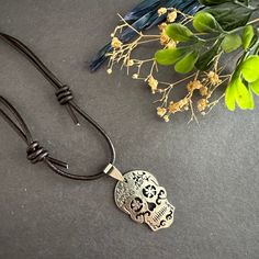 Unleash your edgy and unique style with our Rustic Silver Sugar Skull Necklace. Made with genuine brown leather cords and detailed with a metallic rustic silver tone sugar skull pendant, this necklace is sure to make a statement. It's adjustable, making it a perfect fit for any guy or brave girl looking to add some rock & punk fashion flair to their wardrobe. It adds a touch of edginess to any outfit and it exudes coolness and style. This unique piece is ideal for any occasion. Whether you're dressing up for a night out or getting into the Halloween spirit (if that's the season ☠️), this necklace is sure to make a statement. Upgrade your casual accessory game today! Casual Halloween Jewelry Gift, Casual Skull Jewelry For Gifts, Casual Skull-shaped Jewelry For Gifts, Casual Skull-shaped Jewelry Gift, Punk Style Brown Jewelry For Gift, Casual Skull-shaped Gift Jewelry, Adjustable Skull Necklace For Festivals, Frida Kahlo Earrings, Sugar Skull Necklace