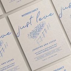 wedding stationery with blue ink and handwritten lettering on white paper, set against a neutral background