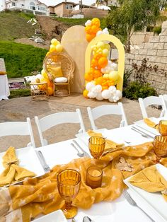 a table set up with yellow and white decorations for an outdoor wedding or baby shower