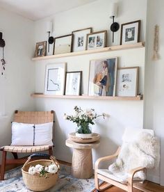 a living room filled with furniture and framed pictures on the wall above it's shelves