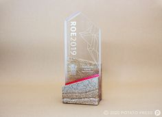 a glass award is shown on a beige background