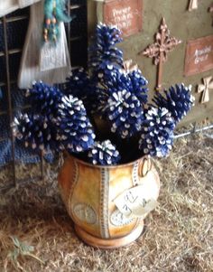 blue flowers are in a vase on the ground next to a wall with crosses and other decorations