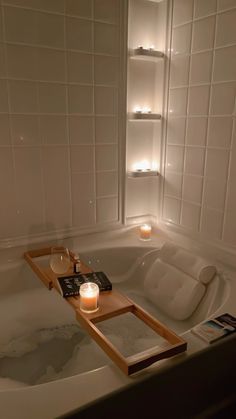 a candle is lit in the middle of a bathtub with two candles on it