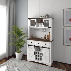 a room with a potted plant and some bottles on top of the cabinets in it