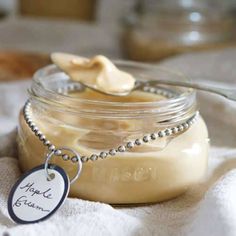 a jar filled with food sitting on top of a white table cloth next to a spoon