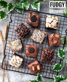 chocolate brownies on a cooling rack with nuts and other toppings next to green leaves