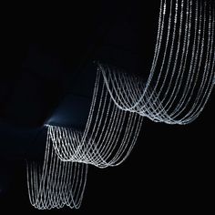 three white lights hanging from the ceiling in a dark room with black walls and flooring