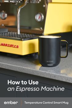 an espresso machine sitting on top of a counter next to a coffee cup