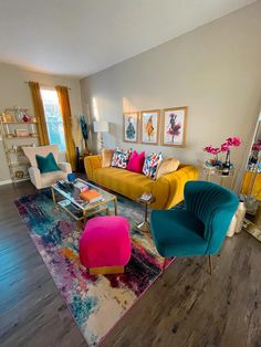 a living room filled with colorful furniture and decor on top of a hard wood floor