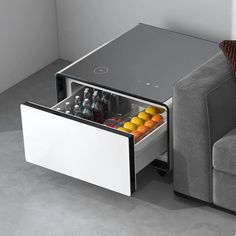 an open drawer on the side of a couch next to a sofa with drinks in it