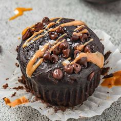 a chocolate cupcake with caramel drizzles on top and frosting