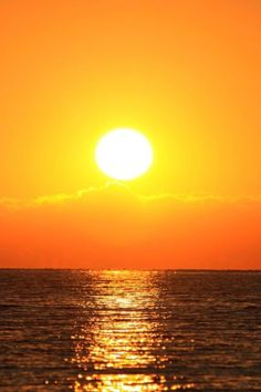 the sun is setting over the ocean with sailboats in the water and one boat on the horizon